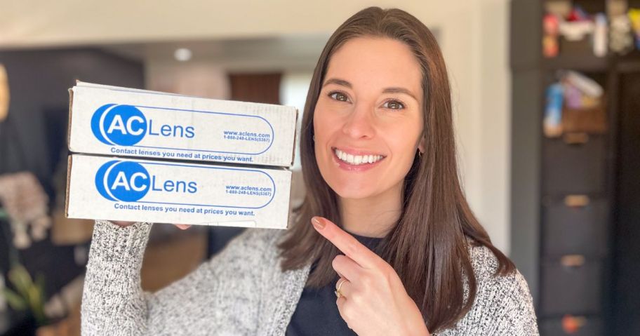 Emily holding and pointing to 2 boxes that say AC Lens