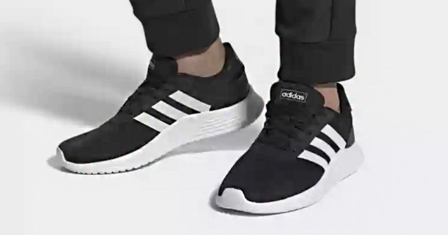 person wearing black and white adidas shoes