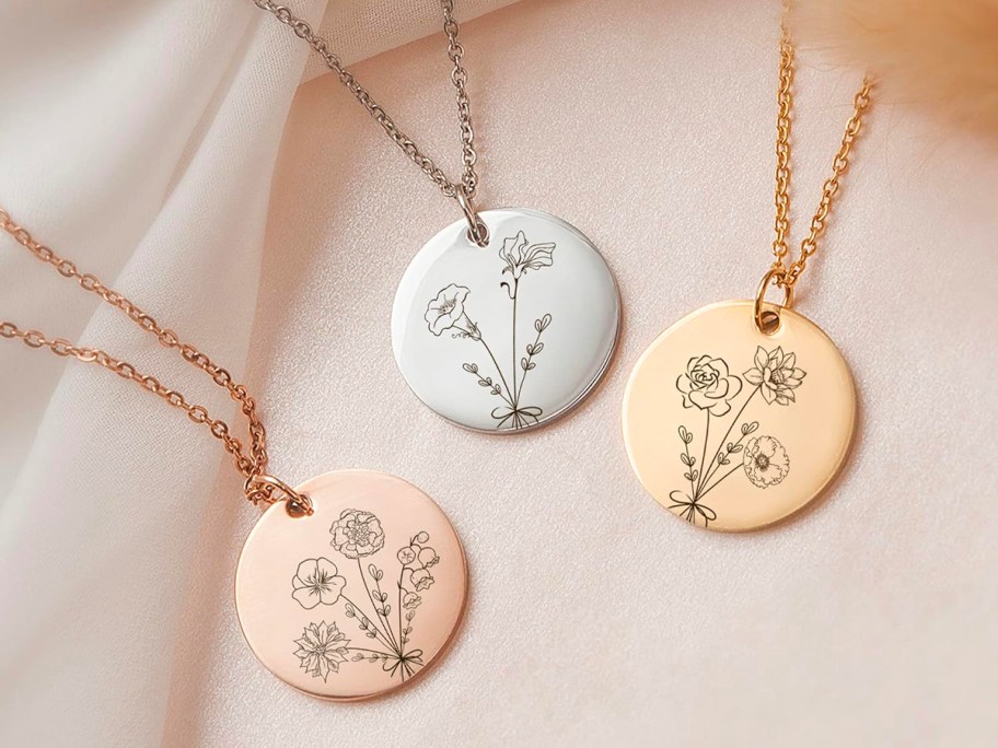 three rose gold, white gold, and gold necklaces w/ discs with flowers 