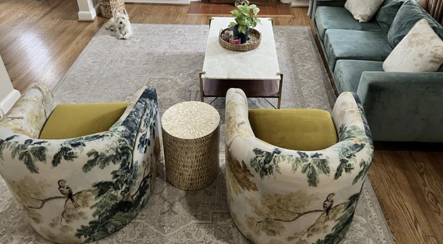living room with two floral swivel chairs and sage couch