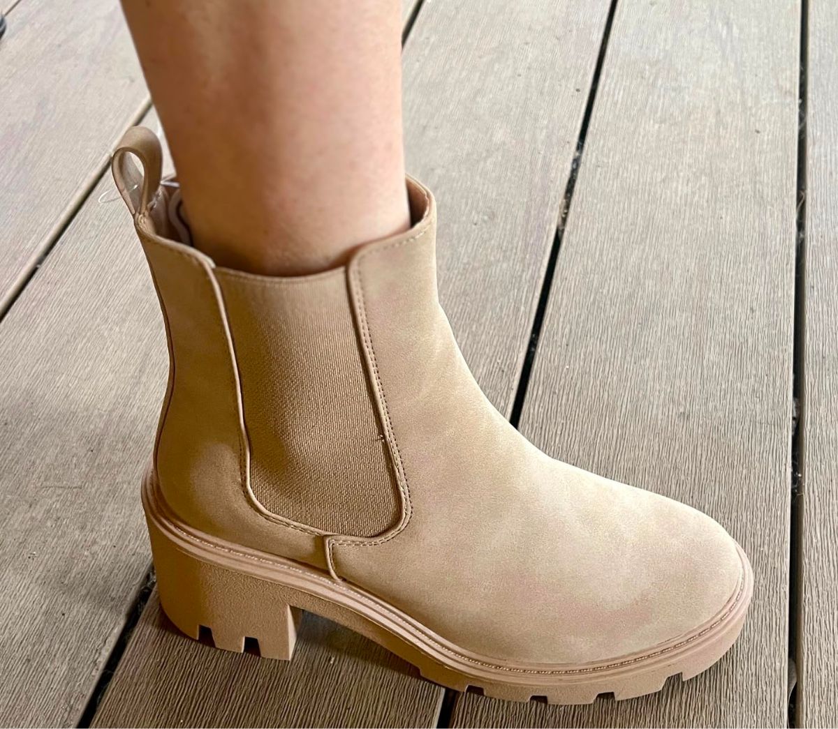a womans foot in a beige suede chelsea boot
