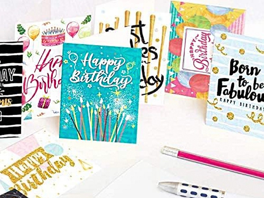 multiple birthday cards standing up on table with pencil 