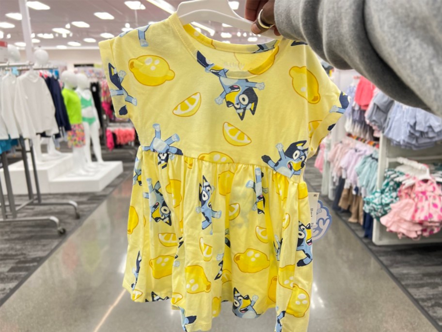 hand holding yellow bluey dress in store