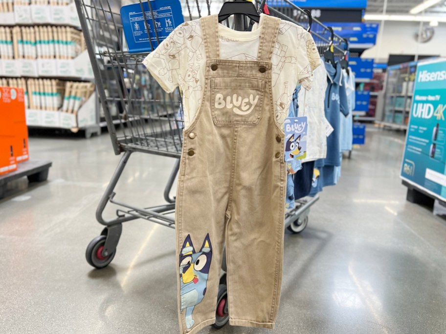 bluey white tee with overalls hanging on shopping cart