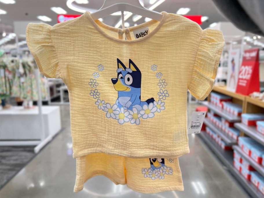 hand holding yellow bluey outfit in store