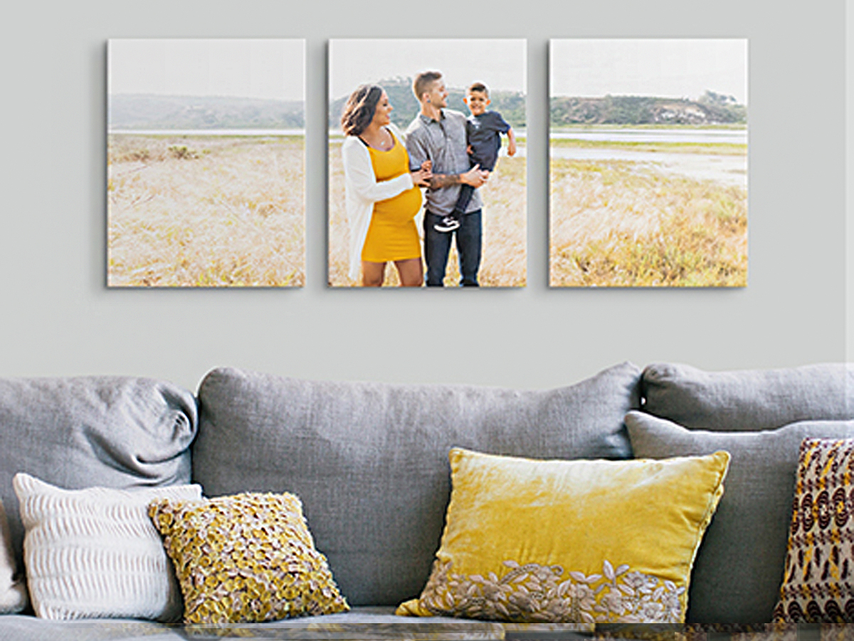 three 11 x 14 canvas prints with family hanging above blue couch