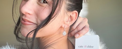 woman holding cate and chloe earrings box wearing teardrop earring
