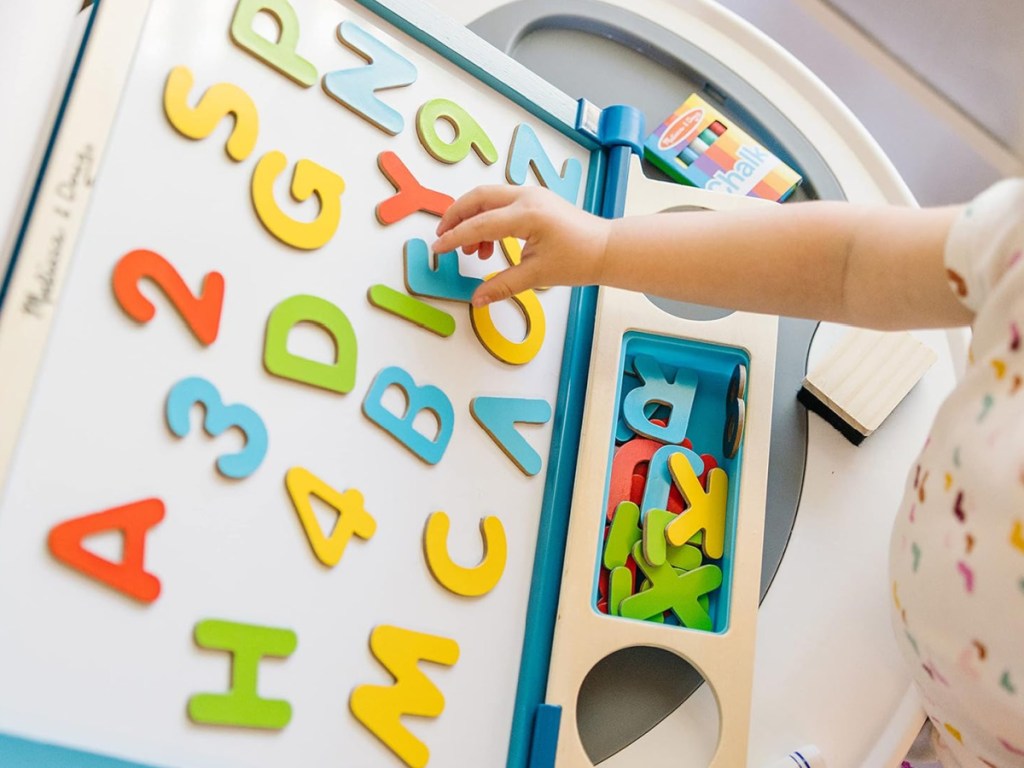 child playing with letters on a board