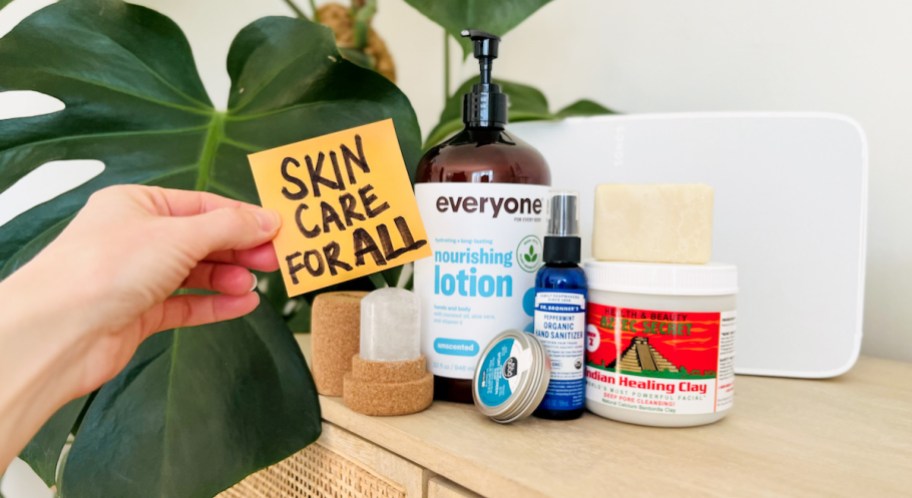 hand holding a post it with best skincare for all and products on table