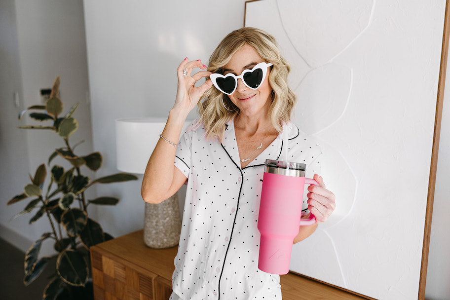 woman with white heart shaped sunglasses and pink tumbler with handle and straw
