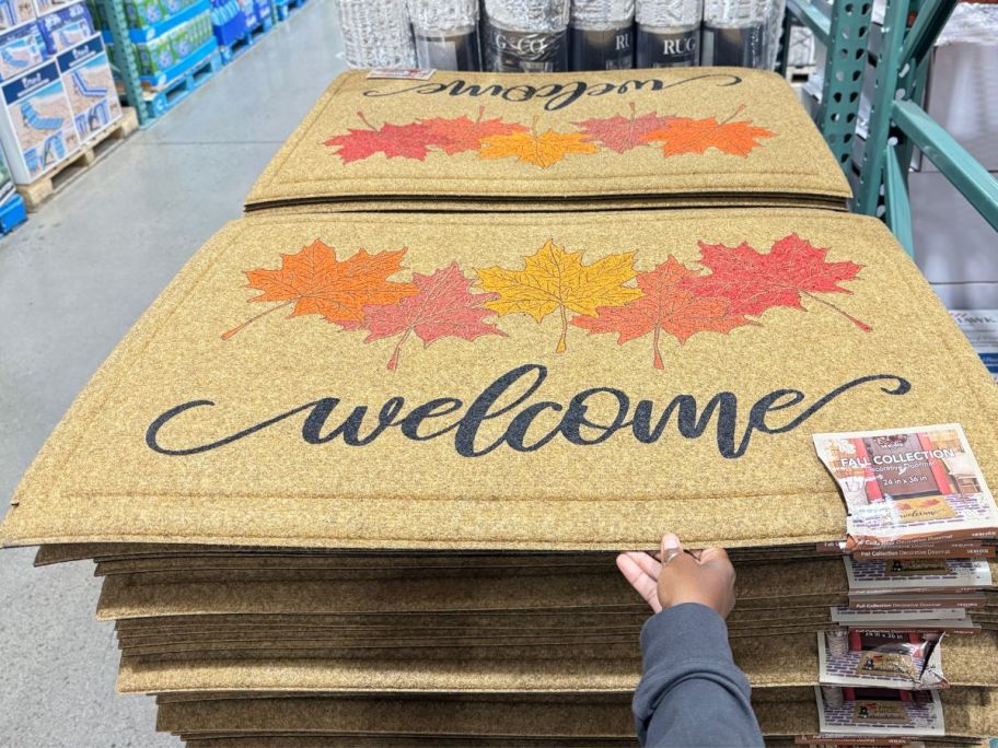 costco welcome fall doormats stacked on display in store