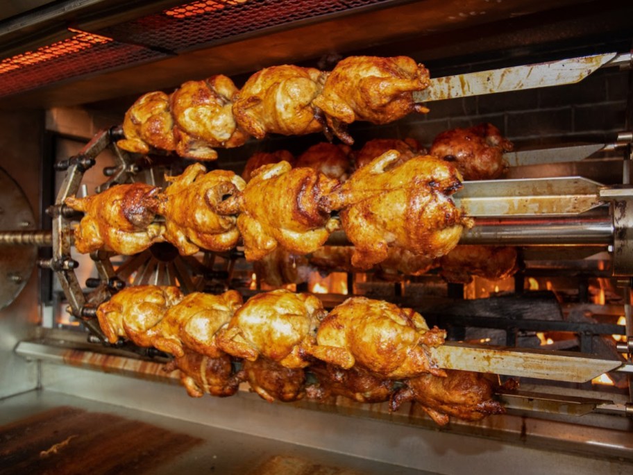 rotisserie chickens roasting in an oven