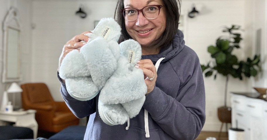 woman holding up blue slippers 