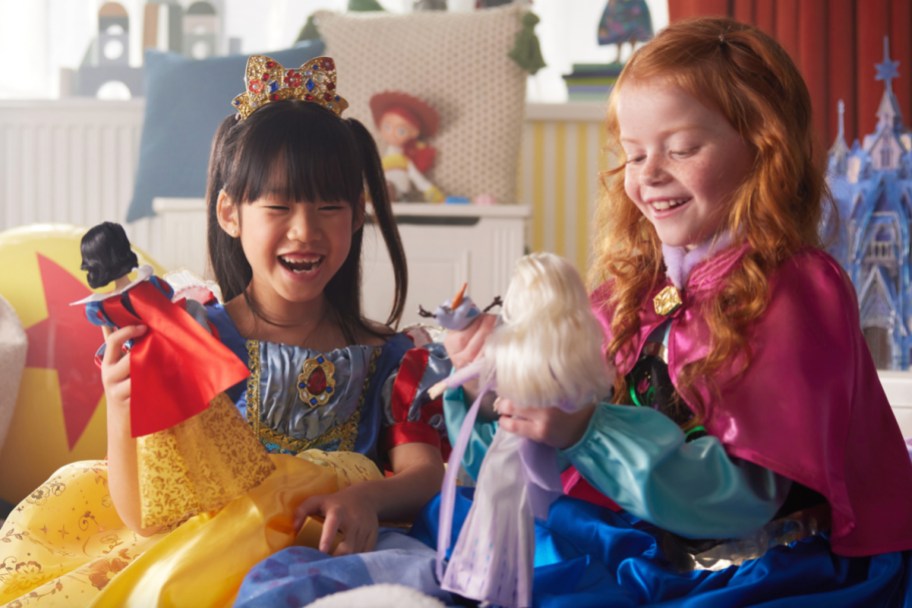 two girls playing with disney dolls
