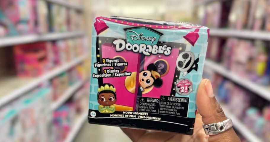 womans hand holding a disney dorable movie moments box