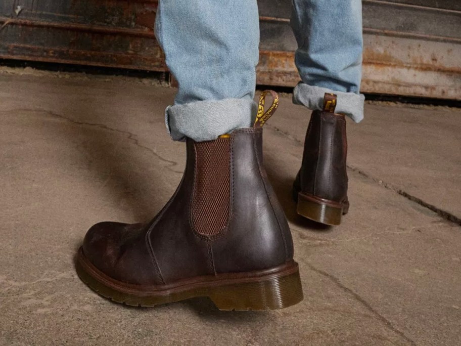 man wearing blue jeans and brown Dr. Martens boots