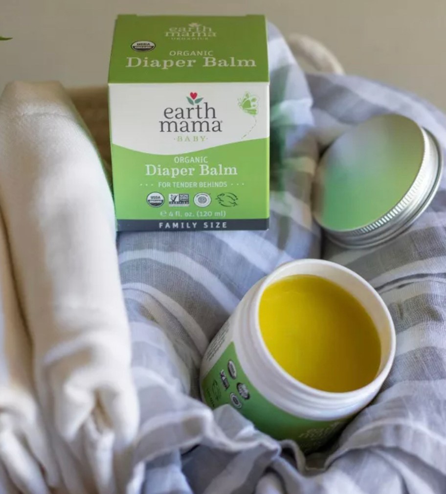 earth mama organic diaper balm on baby blanket in basket