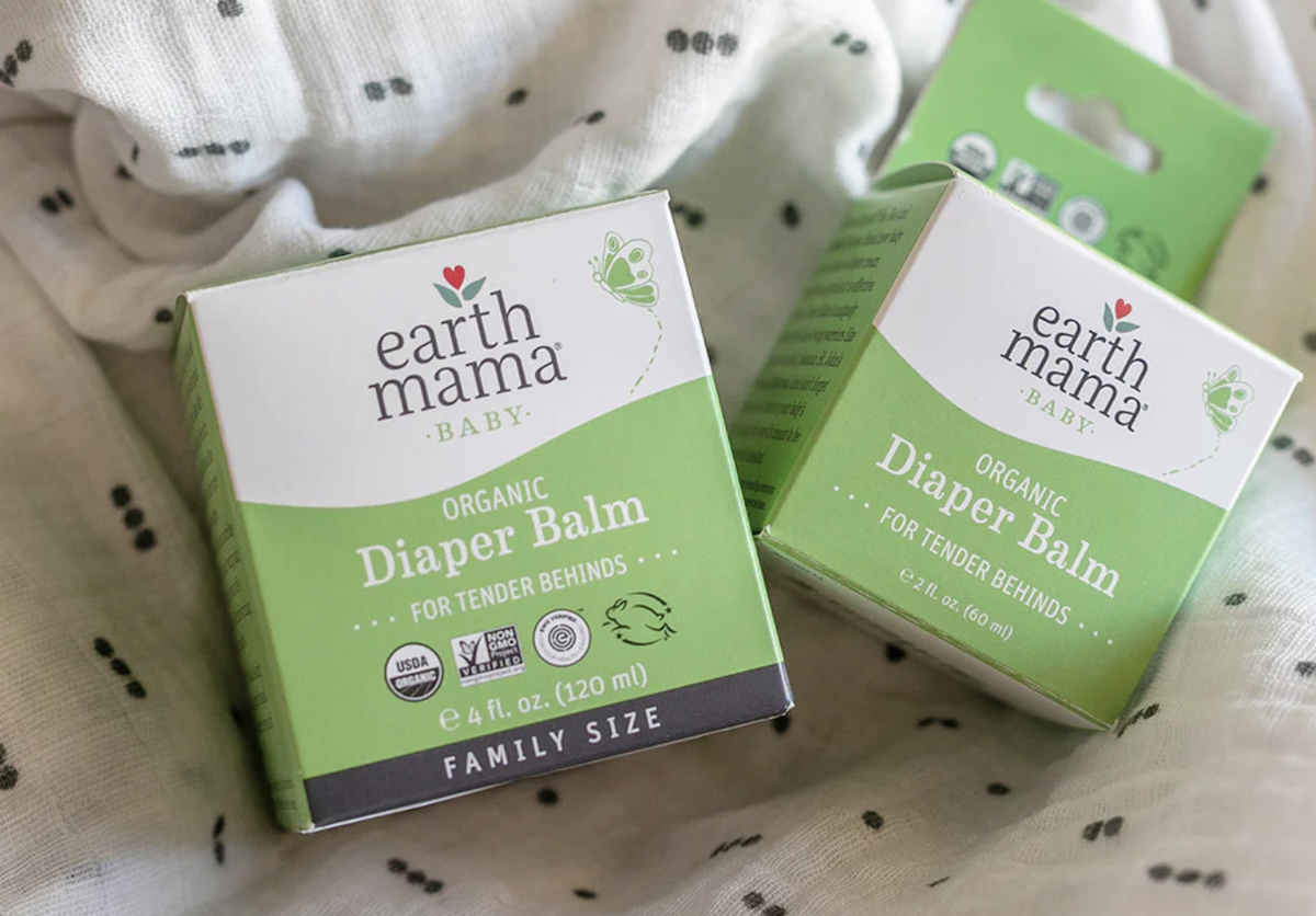 two packs of earth mama organic diaper balm on baby blanket