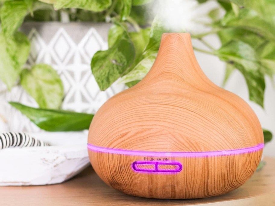 essential oil diffuser with wood grain print and pink light accents