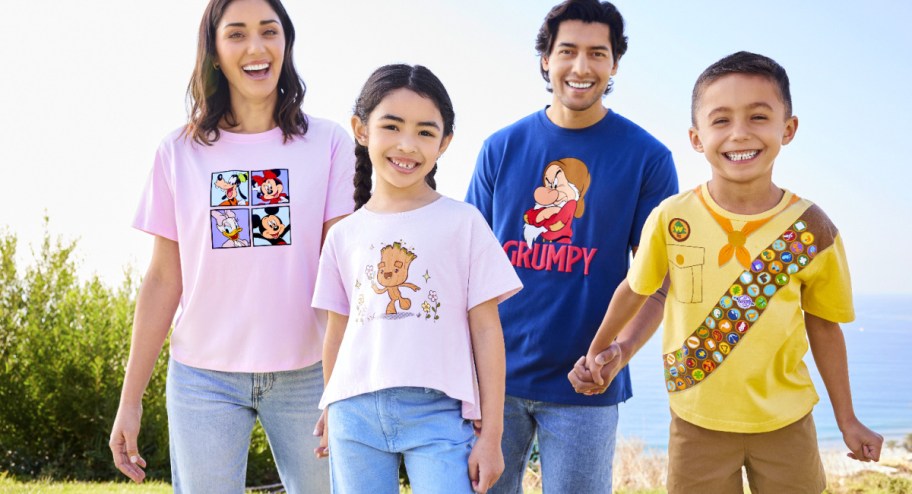 family laughing while wearing Disney t shirts at the park