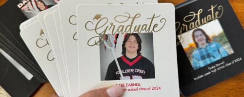 hand holding graduation coasters displayed on the table