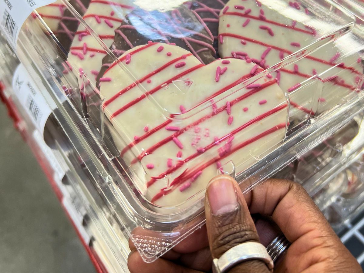 a close up of a cookie in a clam shell of sams club heart shaped sugar cookies