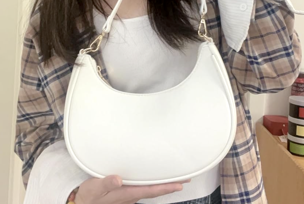 holding white crescent purse