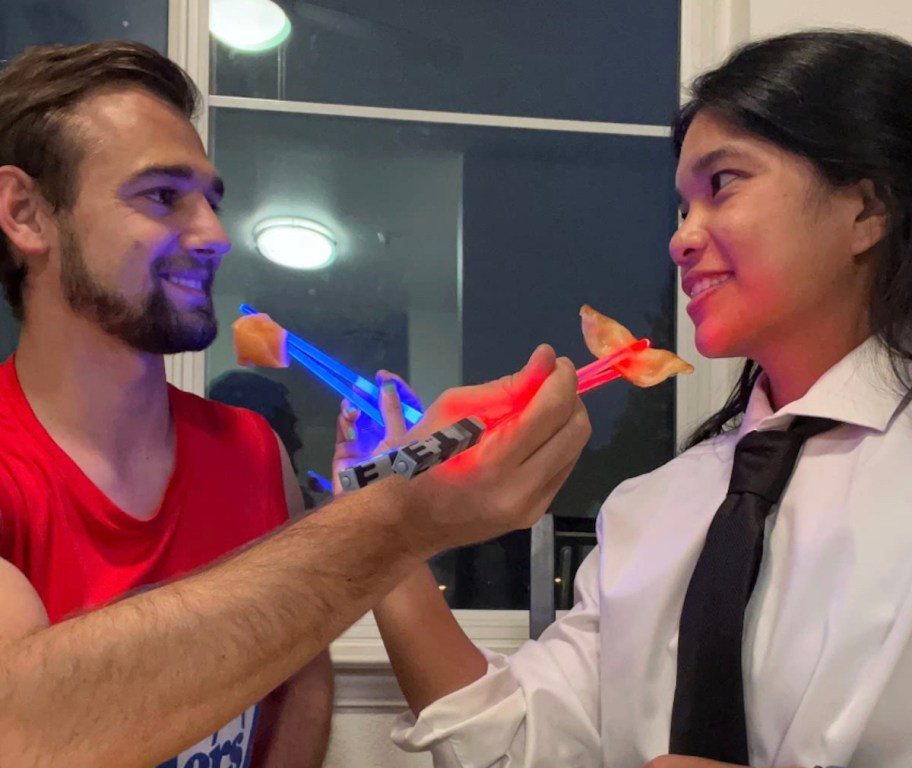 couple feeding each other with light up chopsticks