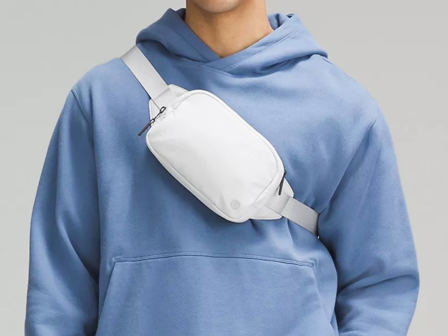 man in blue hoodie with a white belt bag across his chest