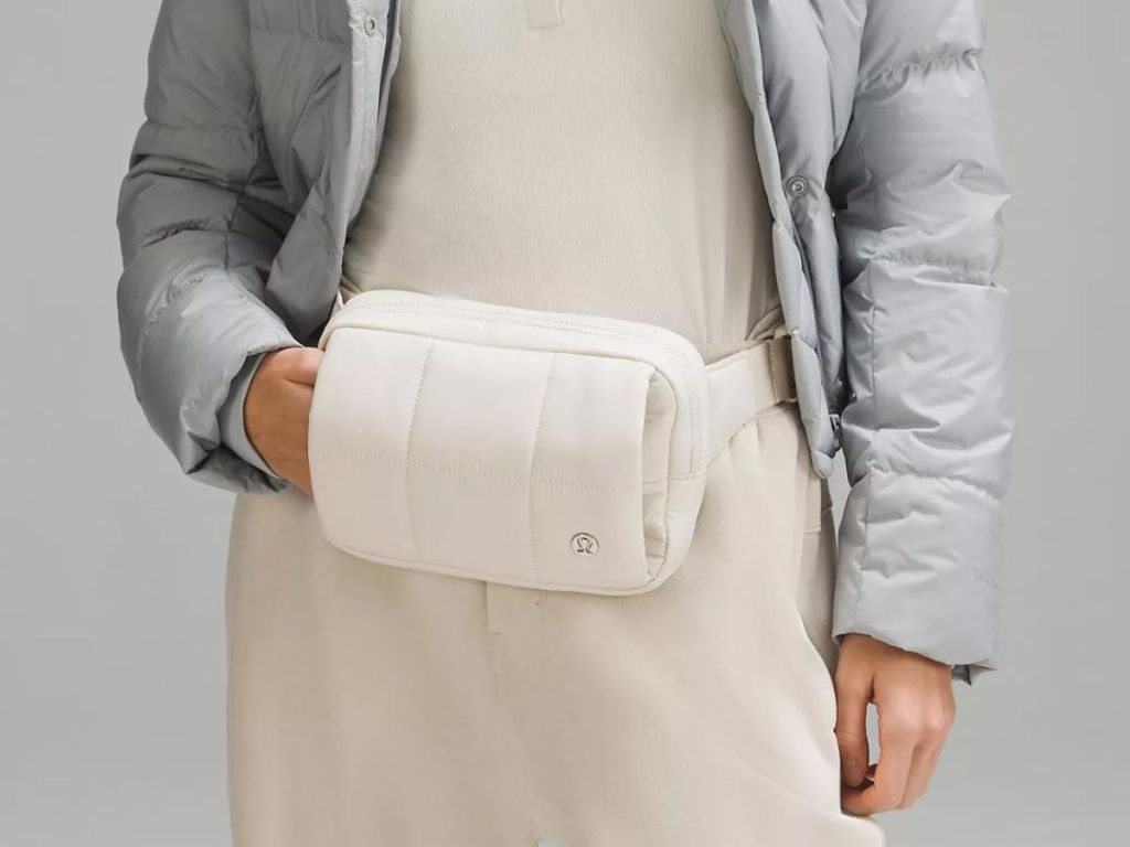 A woman wearing alululemon Quilted Grid Belt Bag Hand Warmer in white