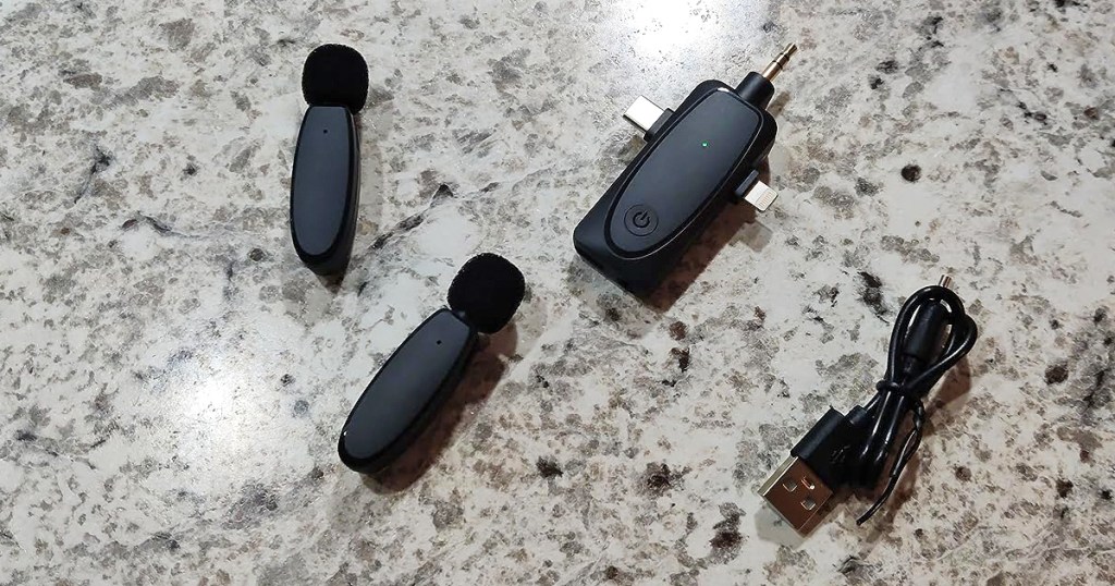 set of clip-on microphones, receiver, and charging cord on counter