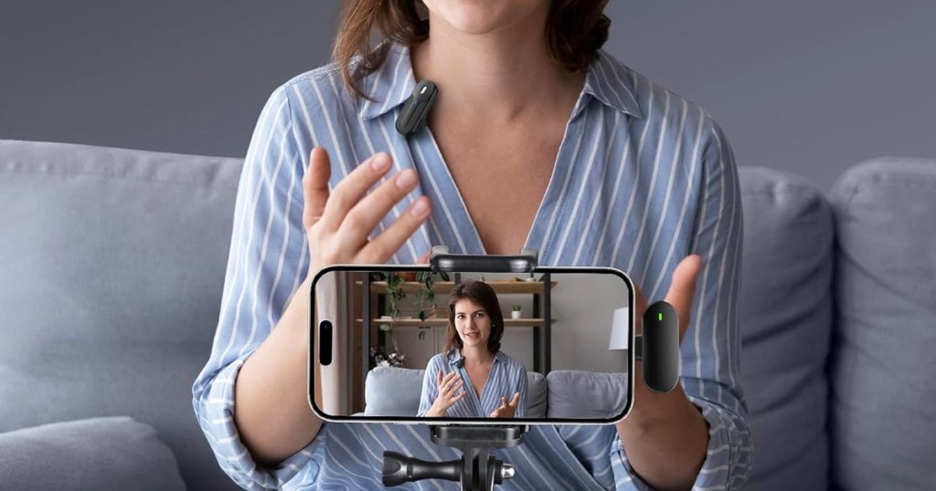 woman recording video of herself using iphone and clip-on microphone