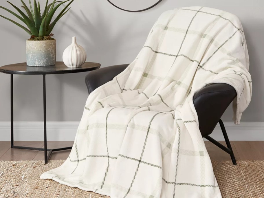 cream and sage green plaid blanket thrown across a side chair 