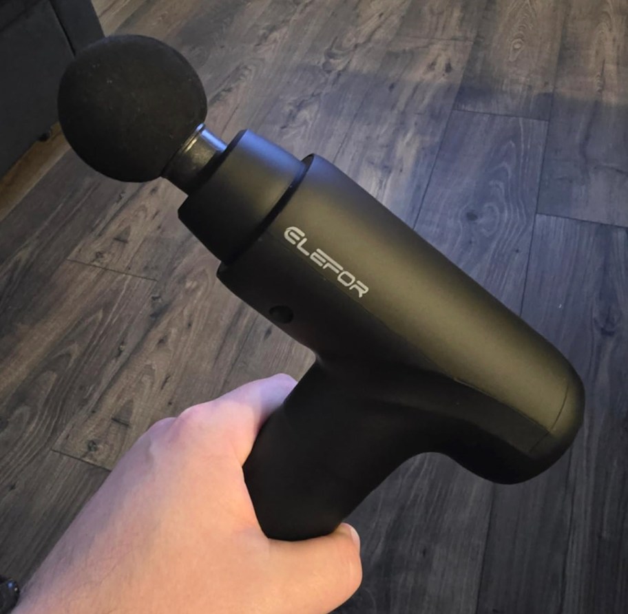 hand holding black massage gun
