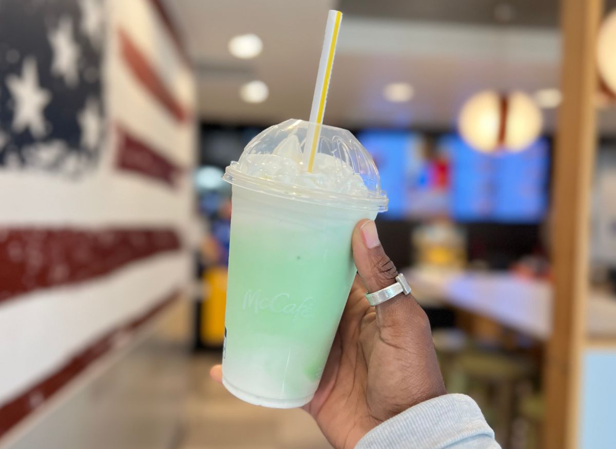 a womans hand displaying a shamrock shake in a mcdonalds