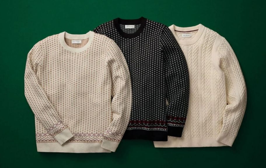 three crewneck mens sweaters on a dark green background