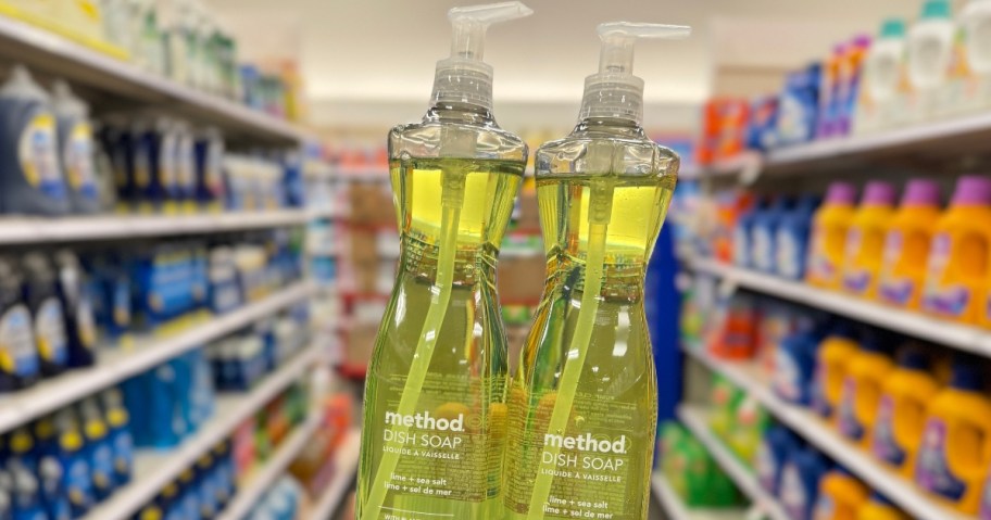 hand holding 2 bottles of yellow Method Dish Soap in a store aisle