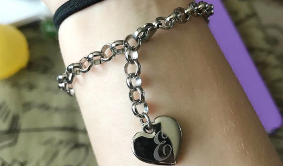 writs with a silver e initial heart charm bracelet 