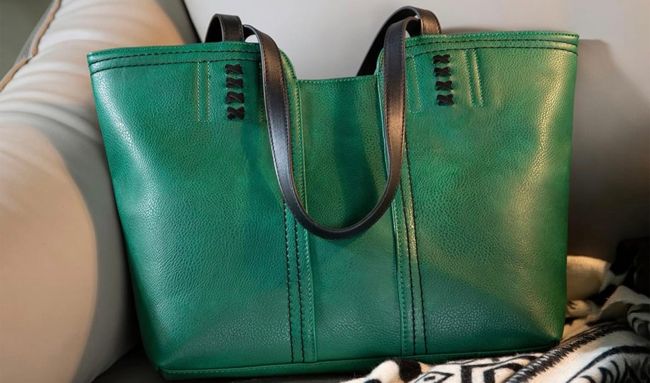 green and black tote sitting on couch