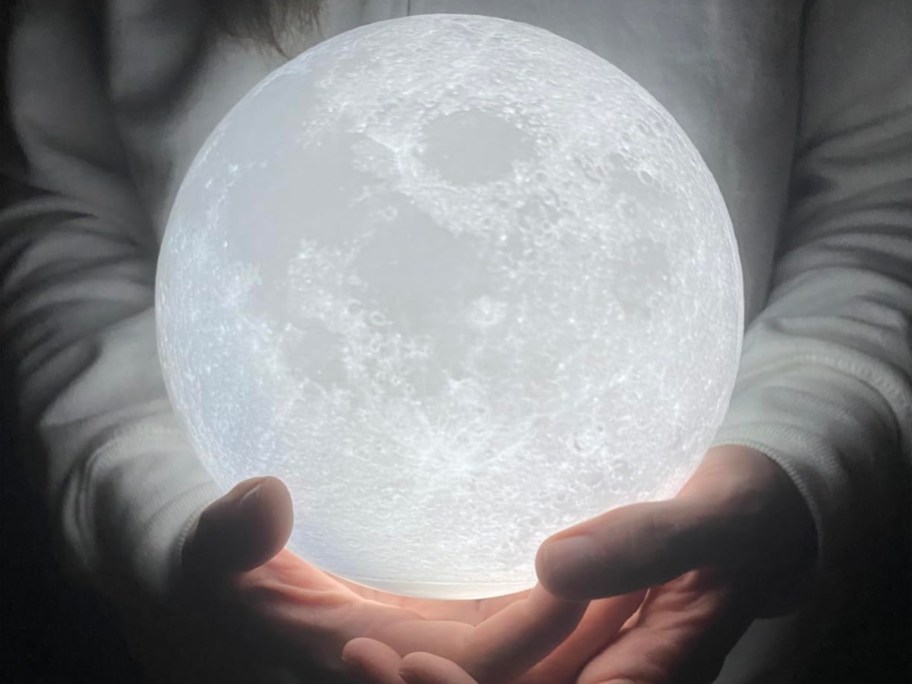 hands holding white moon lamp