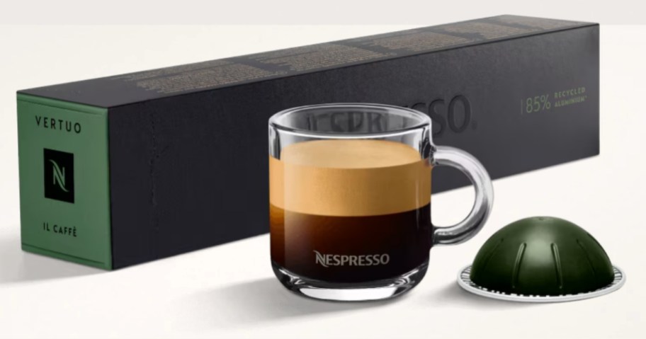 cup of coffee beside a Nespresso pod and a box of pods on the other side