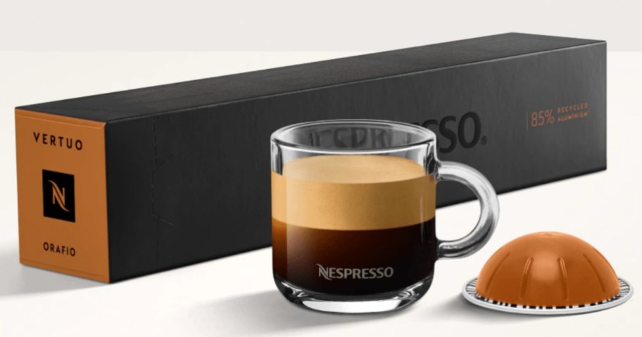 cup of coffee next to a box of Nespresso pods and a single pod