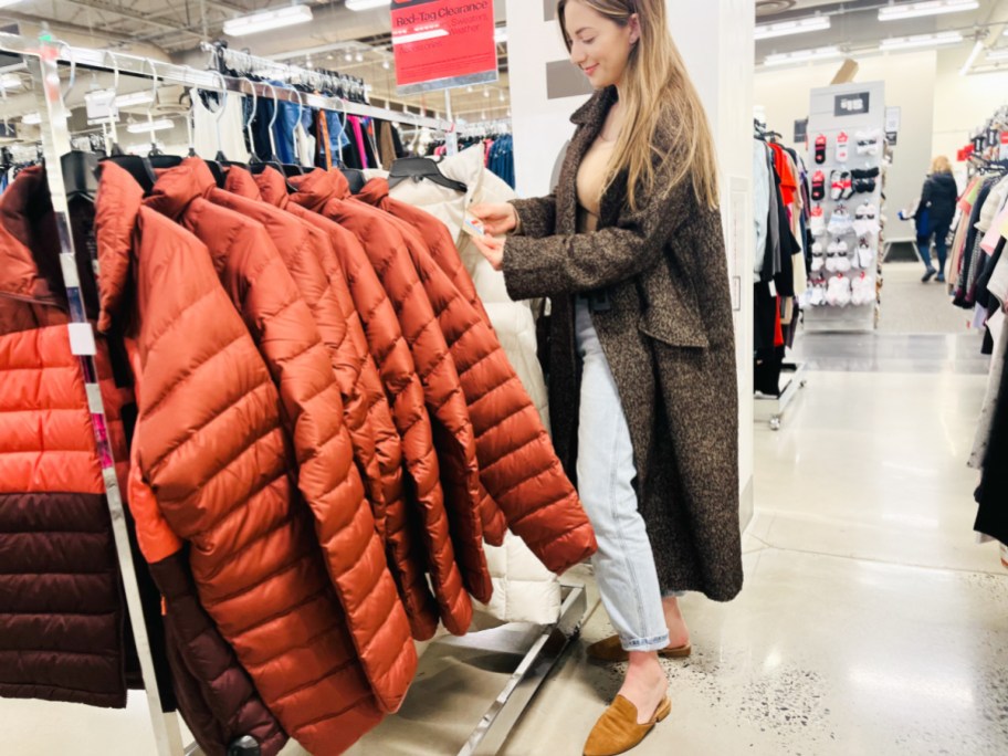 woman standing looking at puffer coats