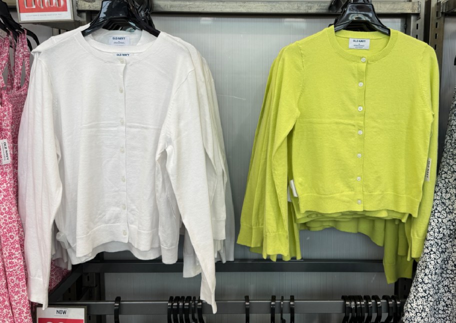 white and green cardigans hanging in store