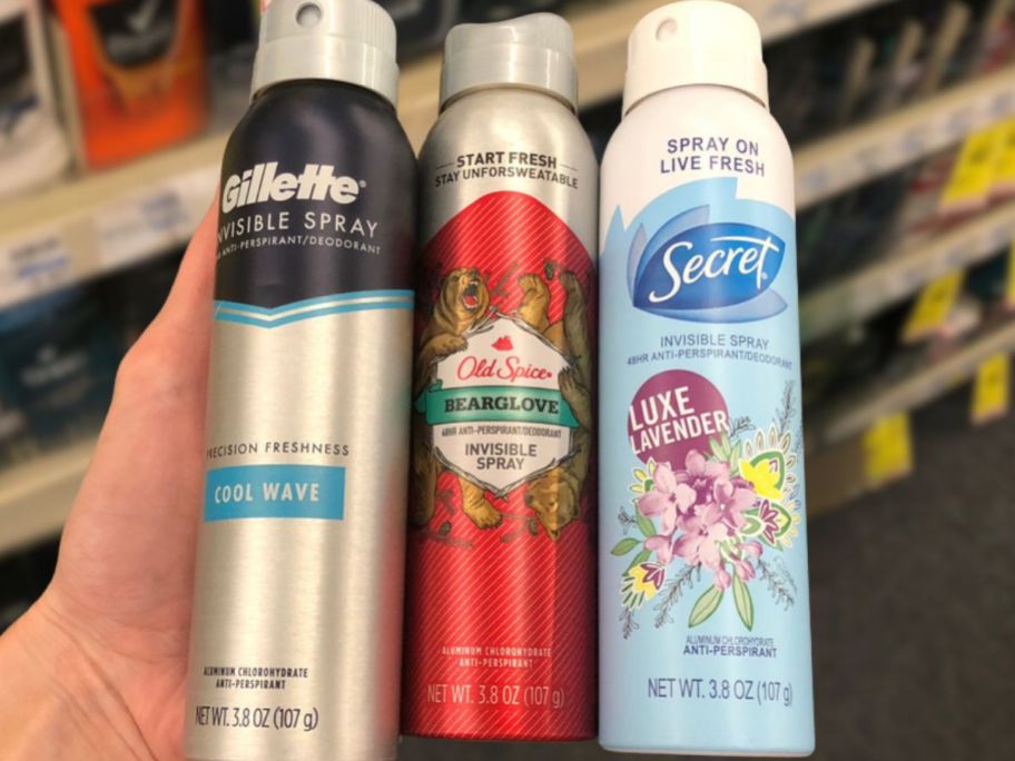 old spice , gilette, and secret spray deodorant being held in store