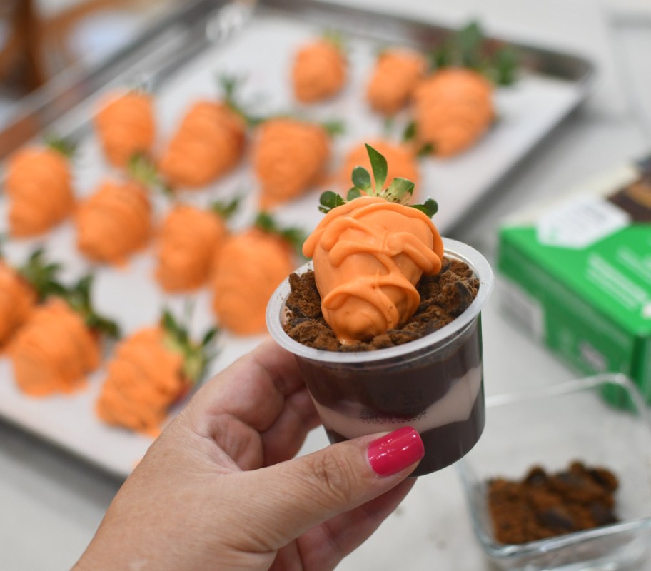 orange carrot strawberry in a pudding cup with cookie crumbs