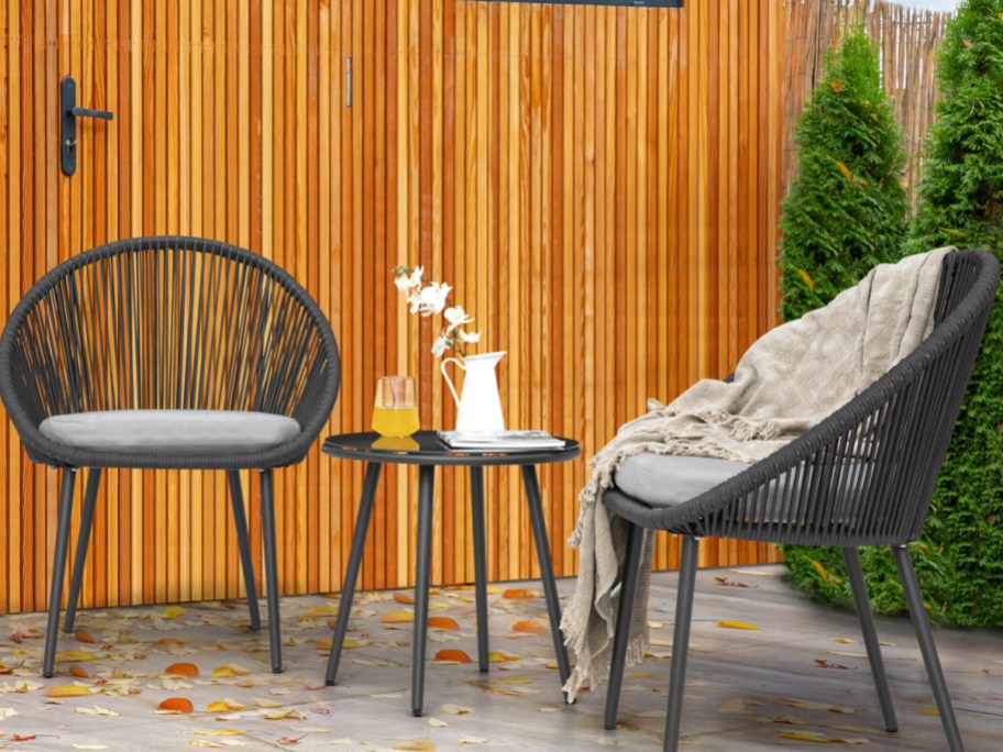 outdoor doom chairs with gray cushions and center table in the middle