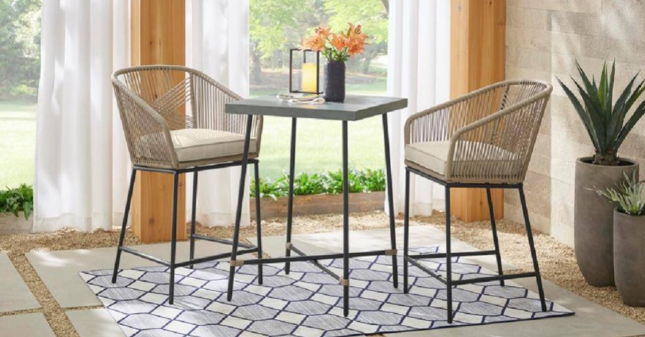 patio chairs outdoors on a rug with a center table and cushions-2