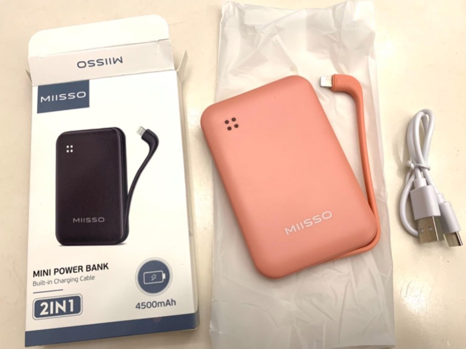 power bank box with charger in pink next to it