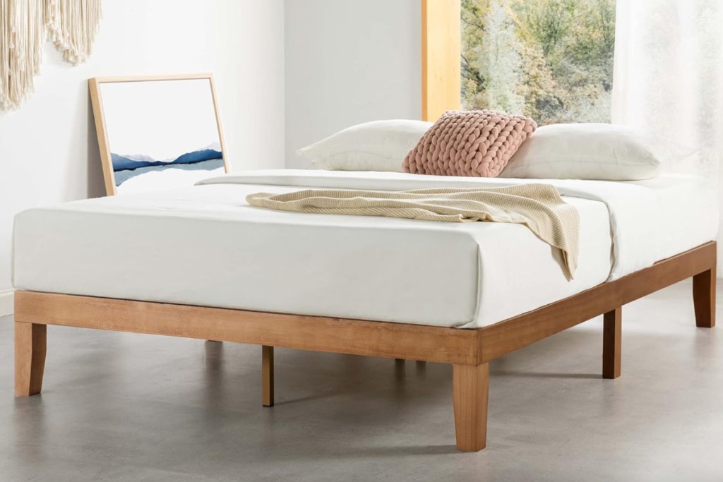 wooden platform bed frame with mattress on it